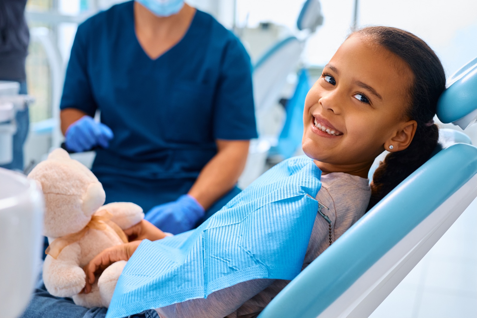 Happy little girl during teeth check-up at dentist's office.