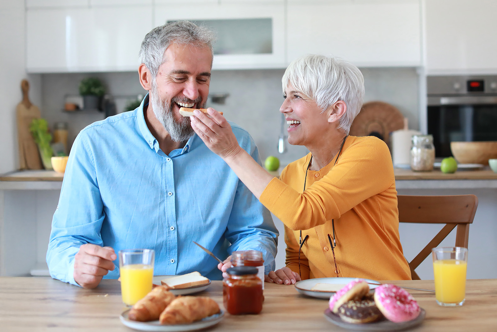 Senior people eating together at home