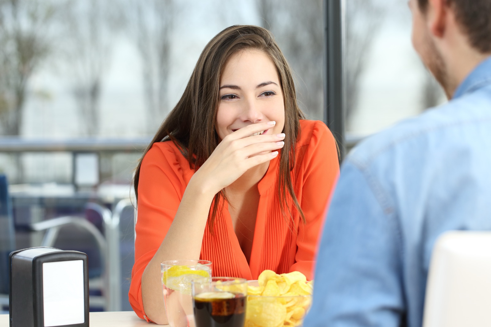 Woman covering her mouth to hide smile or breath